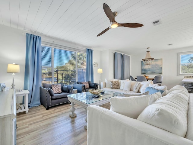 living room featuring wooden ceiling, light wood-type flooring, visible vents, and a ceiling fan