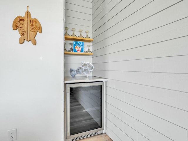 bar featuring wine cooler and wooden walls