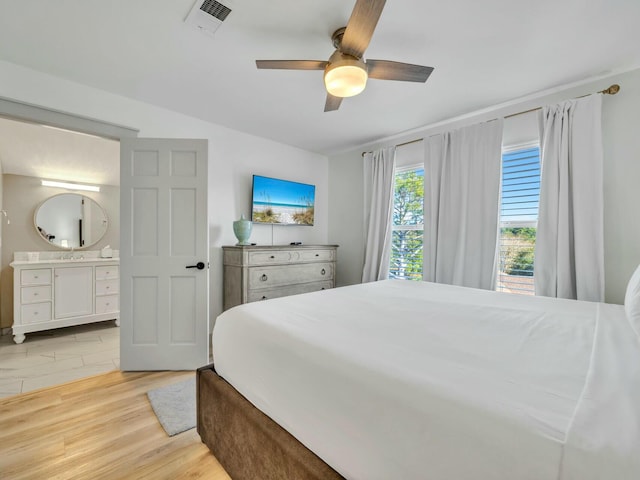 bedroom with visible vents, ensuite bathroom, light wood-style floors, ceiling fan, and a sink