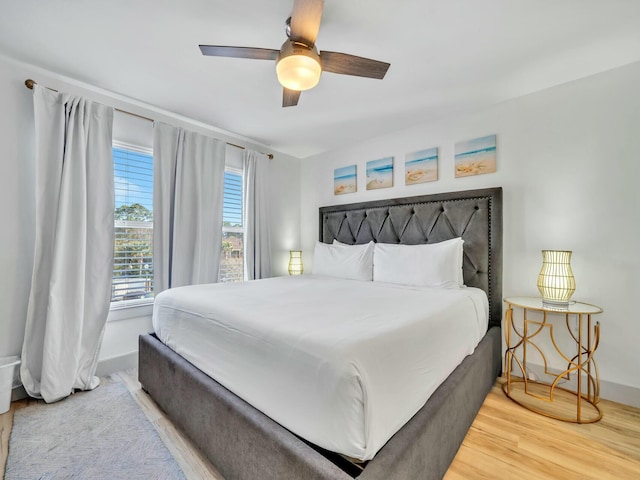 bedroom featuring ceiling fan, wood finished floors, and baseboards