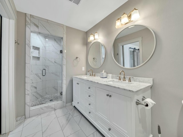 bathroom with double vanity, marble finish floor, a sink, and a stall shower