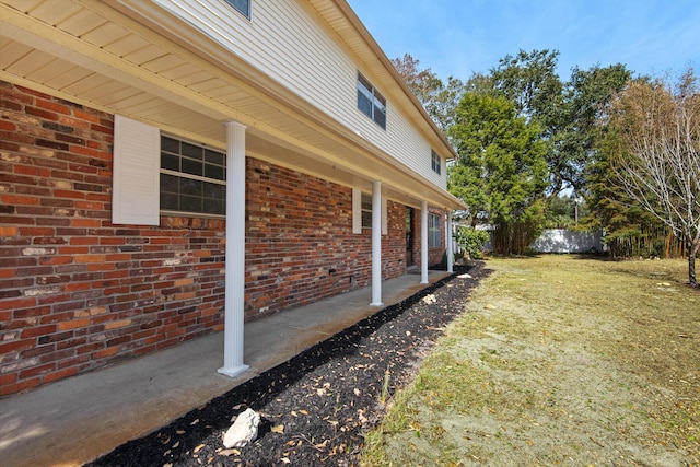 view of property exterior featuring fence and brick siding