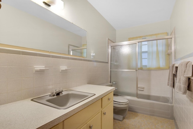 full bathroom with toilet, combined bath / shower with glass door, tile walls, and vanity