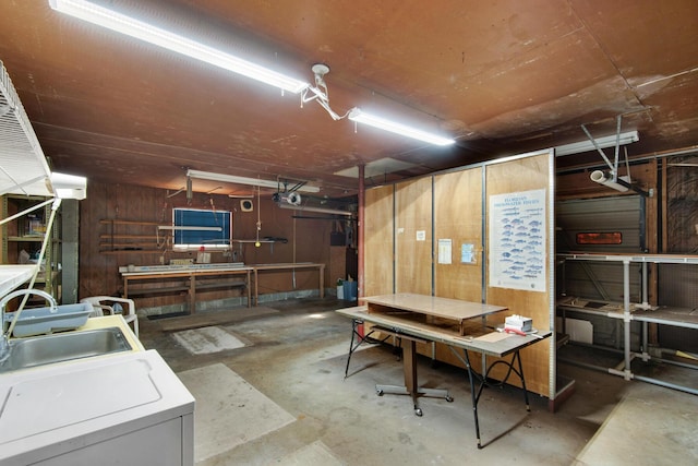 basement with a sink, wooden walls, and a workshop area