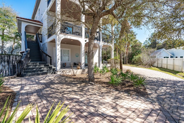 view of patio / terrace with a balcony, stairs, and fence