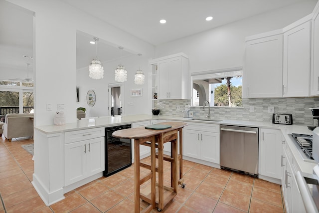 kitchen featuring decorative backsplash, stainless steel dishwasher, white cabinetry, a sink, and beverage cooler