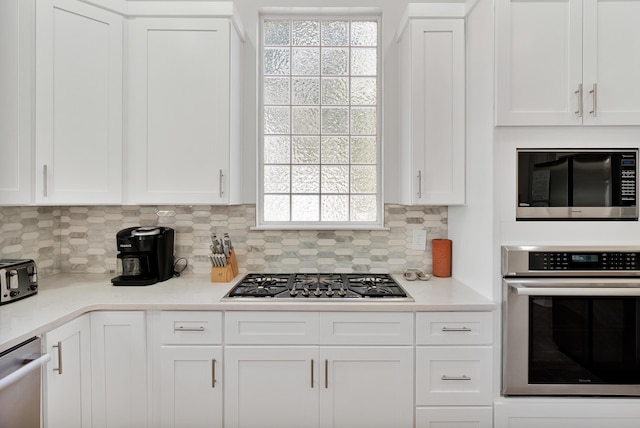 kitchen featuring tasteful backsplash, appliances with stainless steel finishes, white cabinets, and light countertops