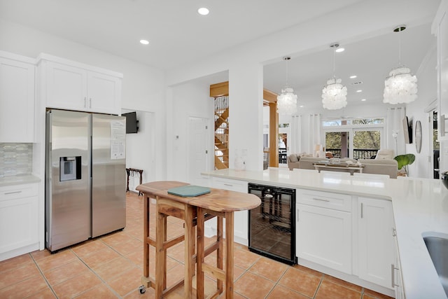 kitchen with beverage cooler, light countertops, and stainless steel fridge