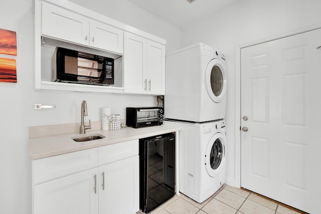 clothes washing area featuring wine cooler, a toaster, light tile patterned floors, stacked washer and dryer, and a sink