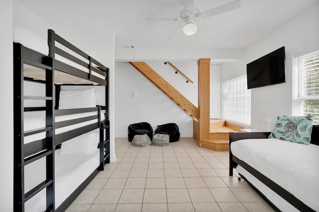 bedroom with light tile patterned floors, visible vents, and a ceiling fan