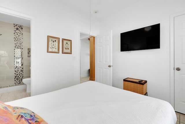 bedroom with ensuite bathroom and light tile patterned flooring