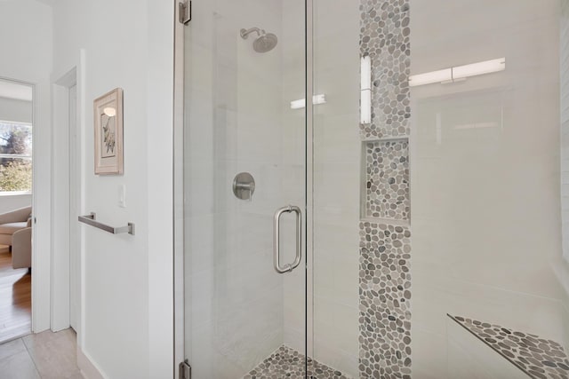 bathroom featuring a stall shower and baseboards