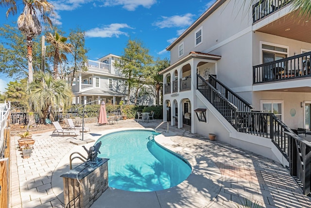 view of pool featuring a patio area, fence, stairway, and a fenced in pool