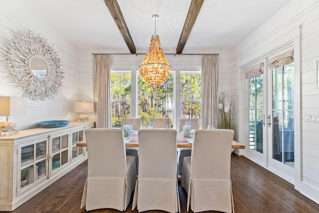 dining room featuring a notable chandelier, dark wood finished floors, wooden walls, and beamed ceiling