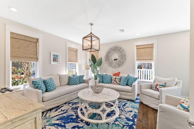 living area with recessed lighting, visible vents, an inviting chandelier, and wood finished floors