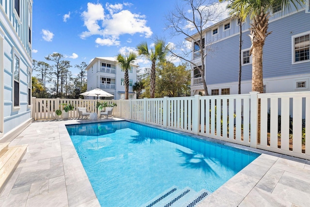 view of swimming pool with a patio area, fence, and a fenced in pool