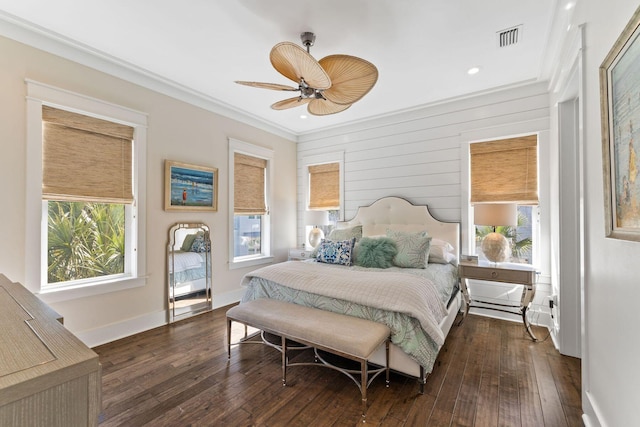 bedroom with wood-type flooring, multiple windows, visible vents, and ornamental molding