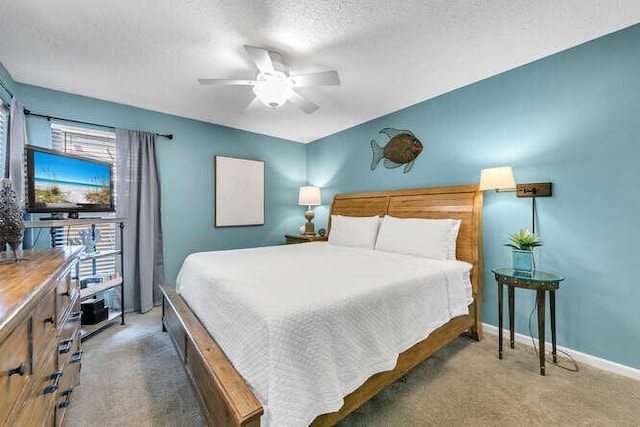 carpeted bedroom featuring ceiling fan, a textured ceiling, and baseboards