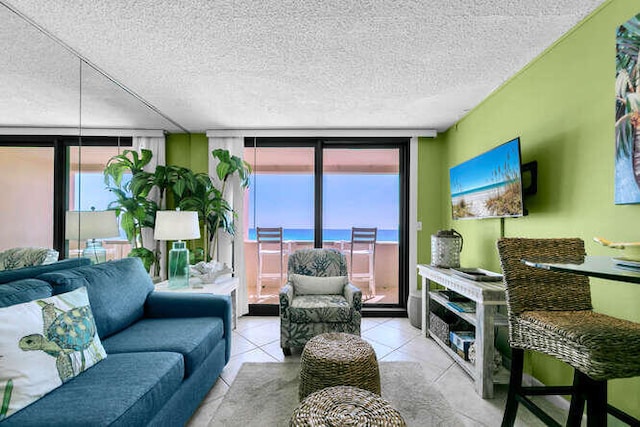 tiled living room featuring a textured ceiling and a wall of windows