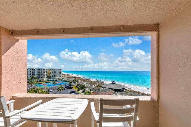 balcony featuring a water view and a view of the beach