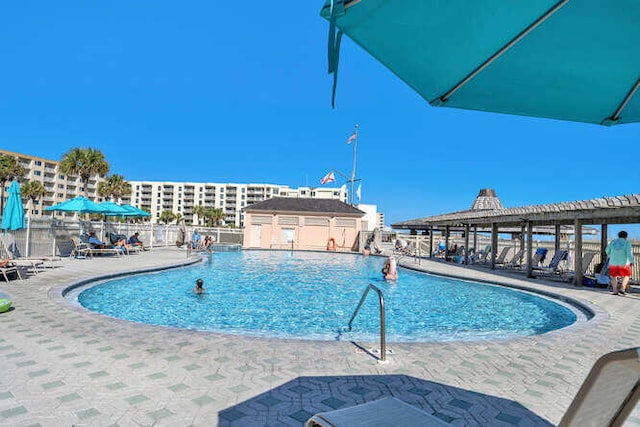 community pool with fence and a patio