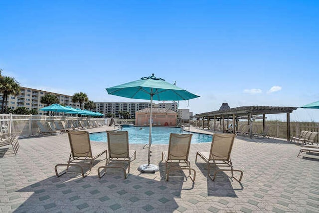 pool with a patio area and fence