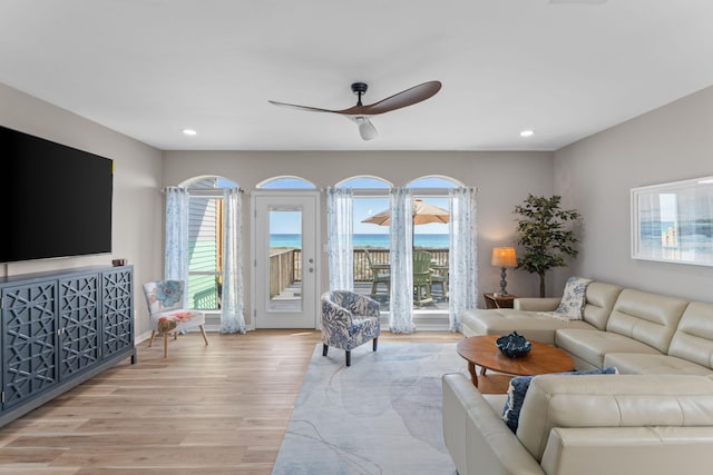 living room featuring light wood-style floors, plenty of natural light, a ceiling fan, and recessed lighting