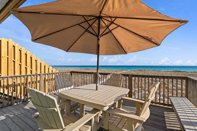 wooden terrace featuring a beach view and a water view