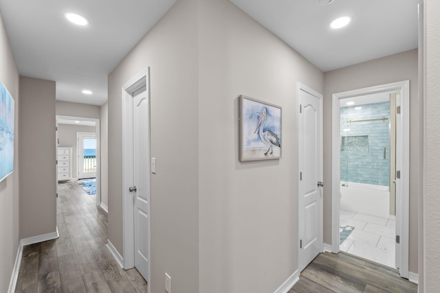 hall featuring recessed lighting, wood finished floors, and baseboards