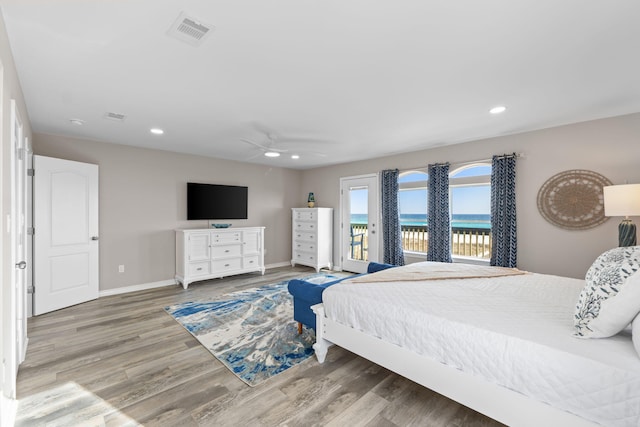 bedroom with recessed lighting, wood finished floors, visible vents, baseboards, and access to outside