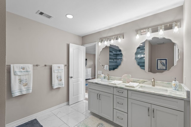 full bath with double vanity, baseboards, visible vents, marble finish floor, and a sink