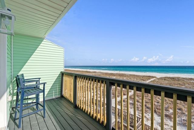 wooden deck with a water view and a beach view