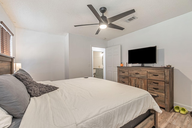 bedroom featuring visible vents, a ceiling fan, a textured ceiling, light wood-type flooring, and baseboards