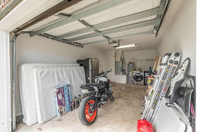 garage featuring a garage door opener, washer and dryer, freestanding refrigerator, and electric water heater