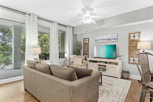 living area with ceiling fan, wood finished floors, and baseboards