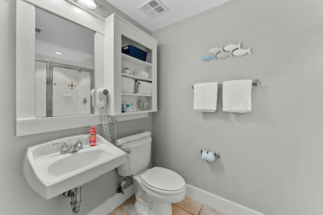 full bath featuring toilet, a sink, a shower stall, tile patterned flooring, and baseboards