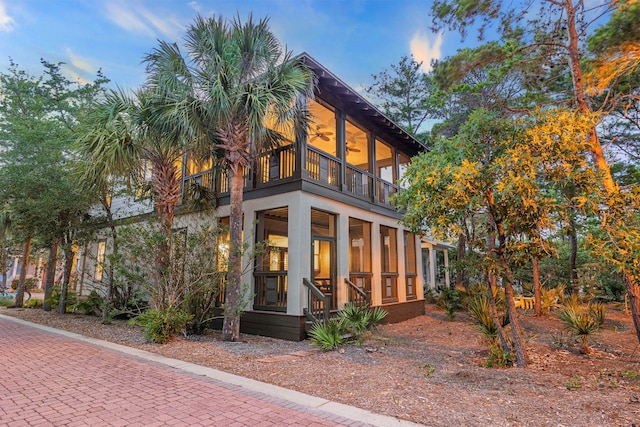 view of front of house featuring a balcony and a sunroom