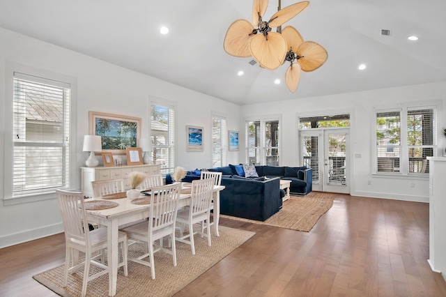 dining area with lofted ceiling, recessed lighting, wood finished floors, baseboards, and french doors