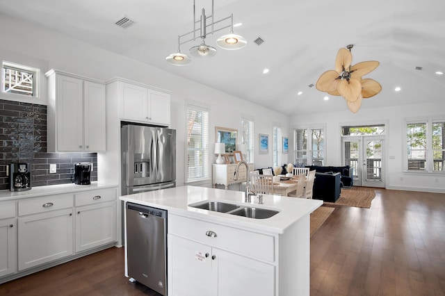 kitchen featuring open floor plan, stainless steel appliances, a sink, and lofted ceiling