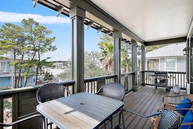 wooden terrace with outdoor dining space and a grill