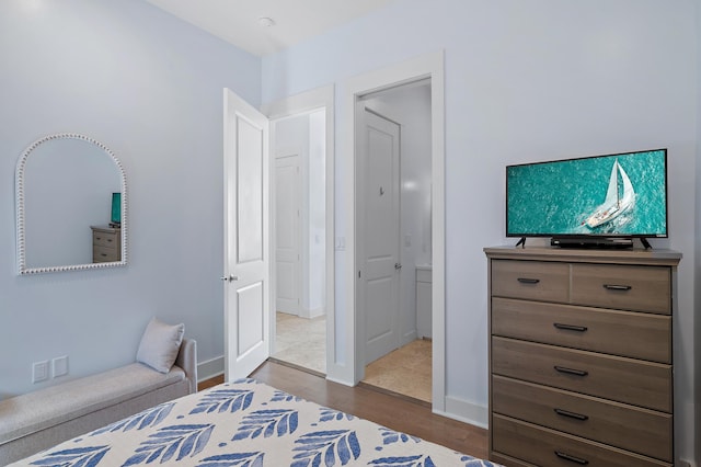 bedroom with baseboards and wood finished floors