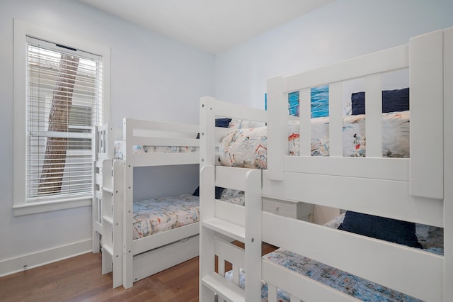 bedroom with baseboards and wood finished floors