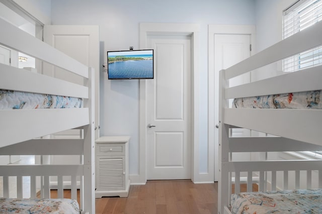 bedroom featuring a crib and wood finished floors