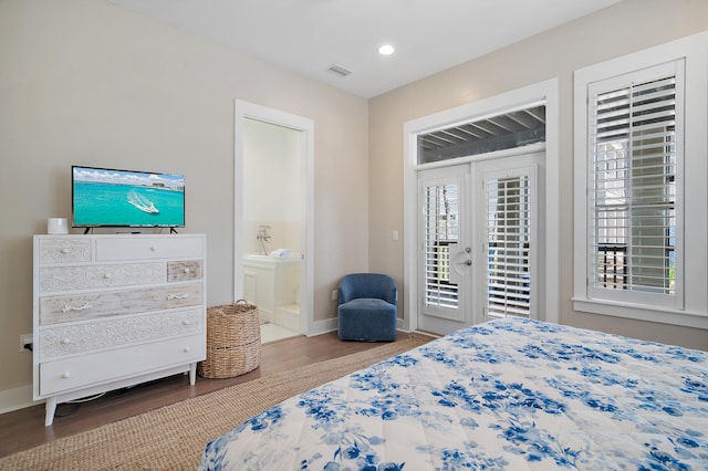 bedroom with connected bathroom, wood finished floors, visible vents, baseboards, and access to exterior