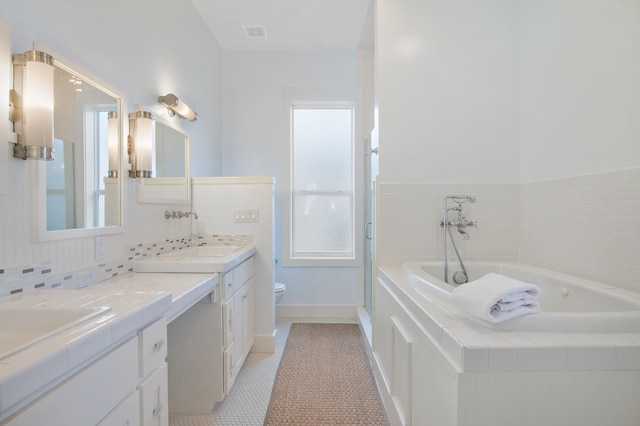 bathroom with toilet, a sink, a bath, tile patterned floors, and double vanity