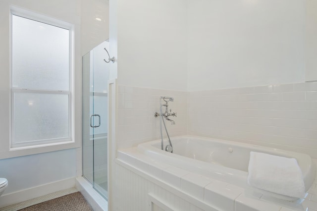 bathroom featuring a shower stall, toilet, and a healthy amount of sunlight