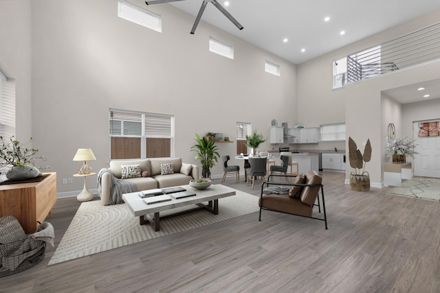 living room featuring recessed lighting, light wood-style flooring, and baseboards