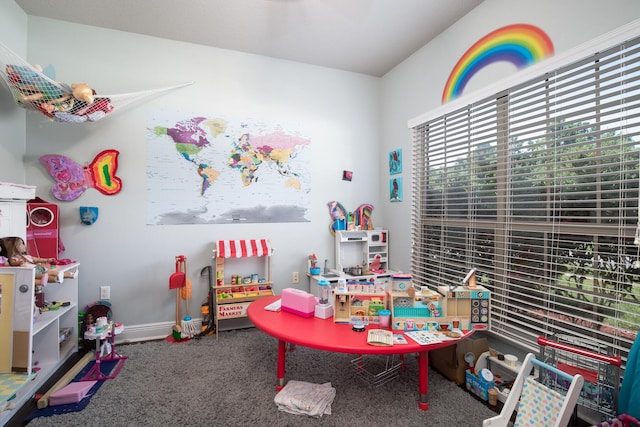 recreation room with carpet and baseboards