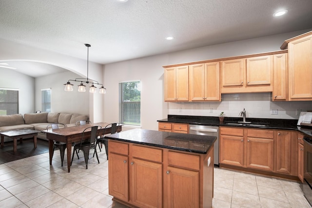 kitchen featuring backsplash, open floor plan, a center island, stainless steel dishwasher, and a sink