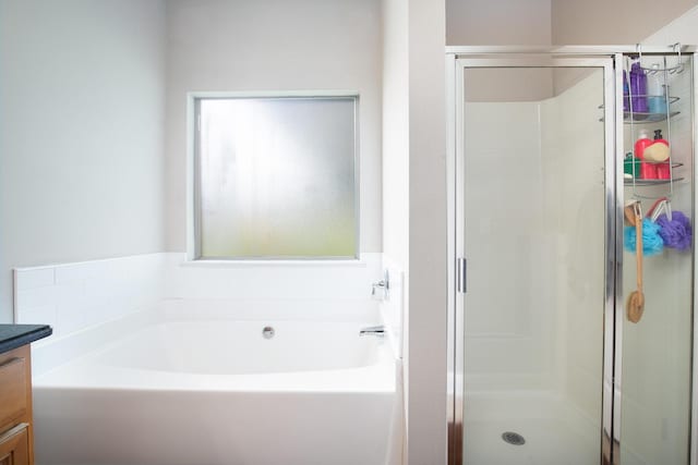 bathroom with a bath, a stall shower, and vanity